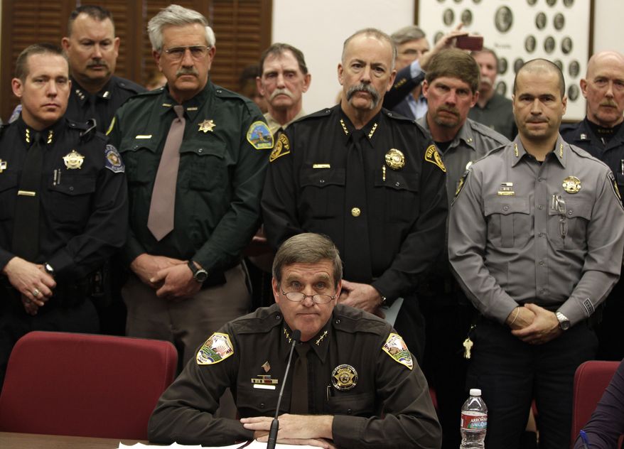 **FILE** Weld County Sheriff John Cooke (center), backed by a group of fellow sheriffs, testifies against proposed gun control legislation in the Colorado Legislature, at the State Capitol in Denver on March 4, 2013. State Senate committees began work on a package of gun-control measures that already have cleared the House which include limits on ammunition magazine sizes and expanded background checks to include private sales and online purchases. (Associated Press)