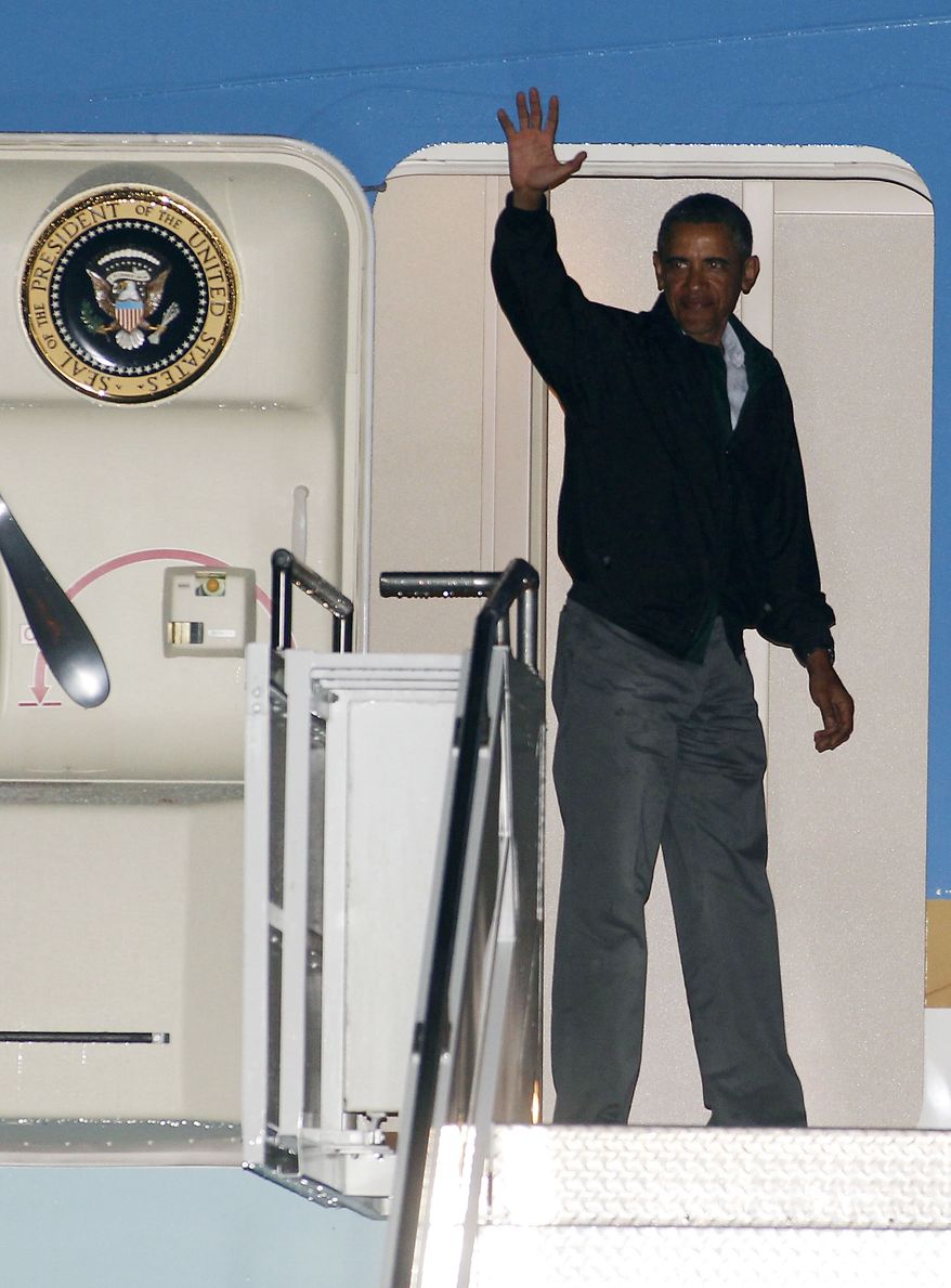 President Obama waves from the door of Air Force One at the Cape Cod Coast Guard Station in Bourne, Mass., on Sunday, Aug. 18, 2013, after ending his vacation on Martha's Vineyard. (AP Photo/Stew Milne)