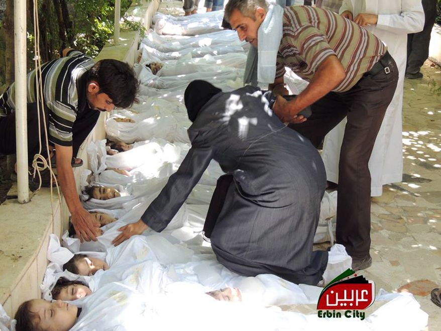This citizen journalism image provided by the Local Committee of Arbeen, authenticated based on its contents and other AP reporting, shows a Syrian man helping a woman as she mourns over the dead bodies of children after an alleged poisonous gas attack fired by regime forces, according to activists in Arbeen town in Damascus on Aug. 21, 2013. Syrian regime forces fired intense artillery and rocket barrages Wednesday on the eastern suburbs of the capital Damascus, in what two pro-opposition groups claimed was a "poisonous gas" attack that killed dozens of people. (Associated Press/Local Committee of Arbeen)