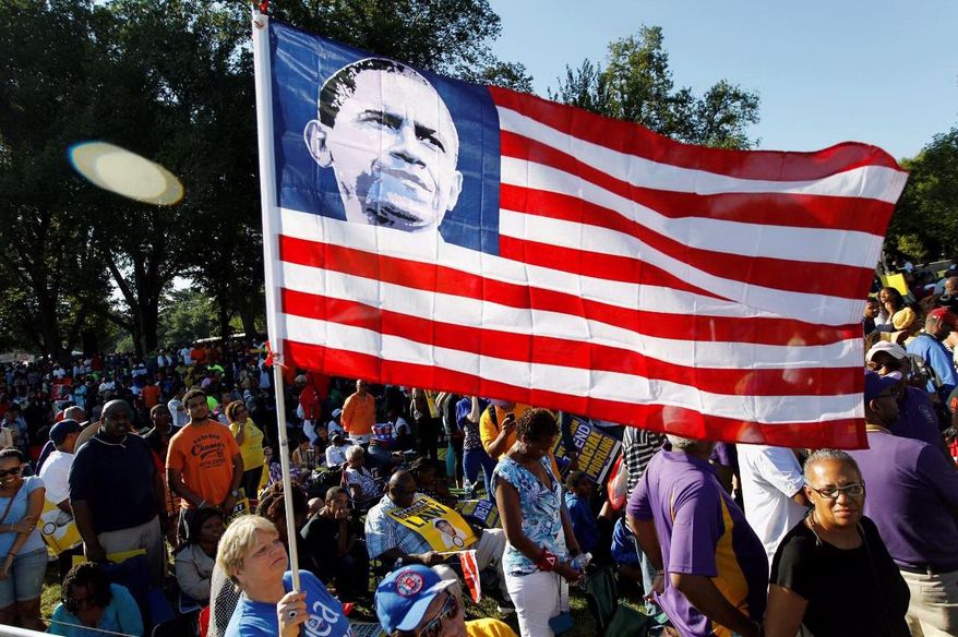 Dorothy Meekins holds up the national flag with the picture of President Barack Obama as she attends the rally, commemorating the 50th anniversary of the 1963 March on Washington at the Lincoln Memorial in Washington, Saturday, Aug. 24, 2013. Organizers have planned for about 100,000 people to participate in the event, which is the precursor to the actual anniversary of the Aug. 28, 1963, march. It will be led by the Rev. Al Sharpton and King's son Martin Luther King III. (AP Photo/Jose Luis Magana)