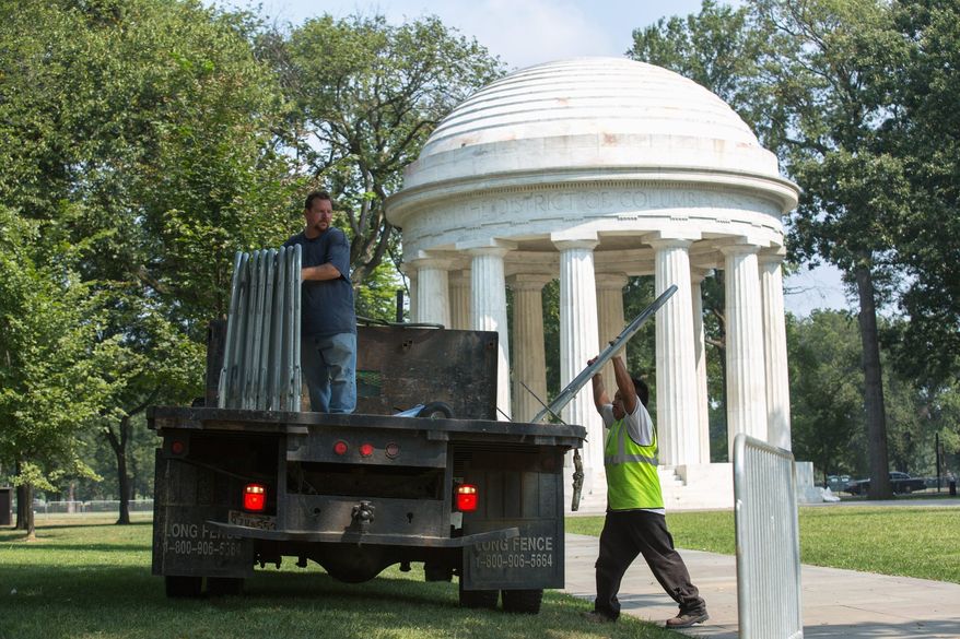 Event specialists unload fences to block off key locations and direct traffic in preparation for Wednesday's commemoration of the 1963 March on Washington. (Andrew S. Geraci/The Washington Times)