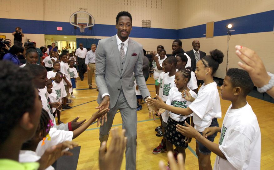 Milwaukee Bucks player Larry Sanders (center) gets high-fives from members of the Boys & Girls Club as he enters the gymnasium before his news conference at the club's Pieper-Hillside branch in Milwaukee on Monday, Aug. 26, 2013. Sanders, who discussed his new four-year contract extension, also donated and handed out several hundred backpacks filled with school supplies to club members. (AP Photo/Milwaukee Journal Sentinel, Mike De Sisti)