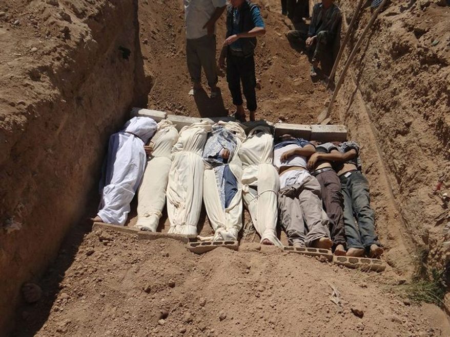 This authenticated image from Aug. 21 purports to show several bodies being buried during a funeral in a suburb of Damascus after a chemical weapon was used against civilians. (Shaam News Network via Associated Press)