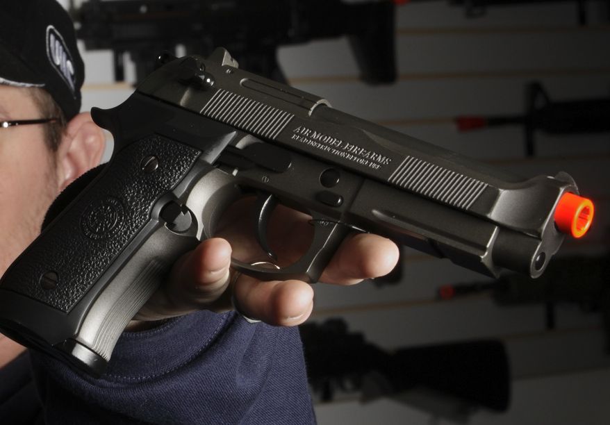 **FILE** Jason Pfingsten, owner of Pacific Rim Airsoft, Ltd., shows a airsoft semi-automatic pistol designed to look like a real Beretta at his Seattle store on Feb. 13, 2008. (Associated Press/Andy Rogers, Seattle Post-Intelligencer)