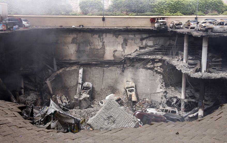 ** FILE ** This photo released by the Kenya Presidency shows the collapsed upper car park of the Westgate Mall in Nairobi, Kenya, Thursday, Sept. 26, 2013. Working near bodies crushed by rubble in a bullet-scarred, scorched mall, FBI agents continued fingerprint, DNA and ballistic analysis to help determine the identities and nationalities of victims and al-Shabab gunmen who attacked the shopping center, killing more than 60 people. (AP Photo/Kenya Presidency)