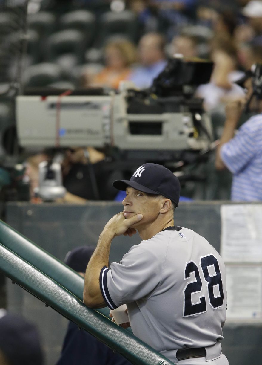 New York Yankees manager Joe Girardi watches the scoreboard from the dugout as the Yankees play the Houston Astros during a baseball game Sunday, Sept. 29, 2013, in Houston. The Yankees won the game 5-1 in 14 innings. (AP Photo/Richard Carson)