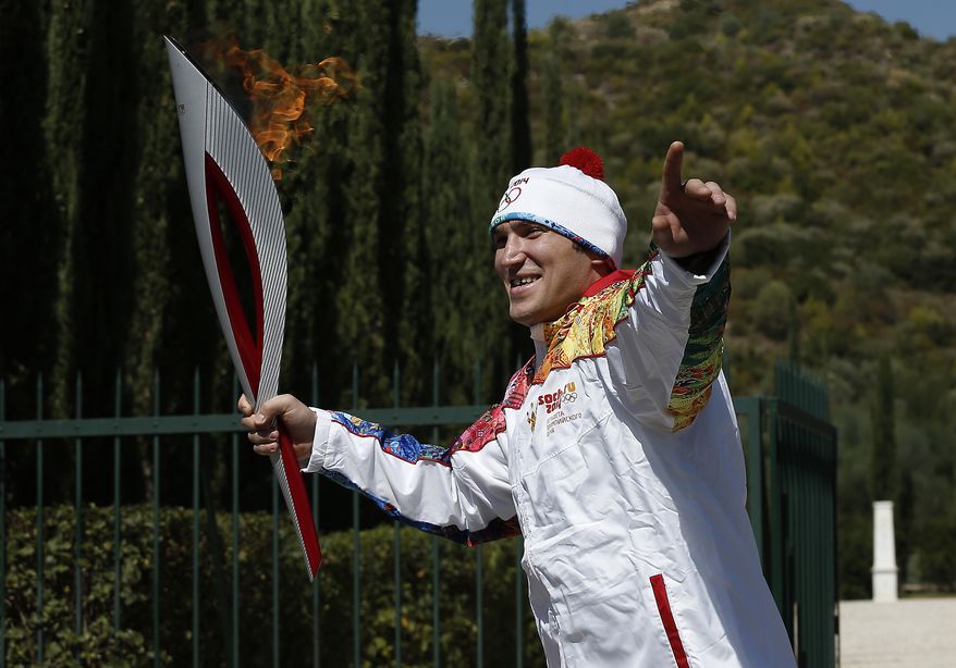 Second torchbearer Alexander Ovechkin of Russia, professional ice hockey winger and captain of the Washington Capitals, leaves the monument of Pierre de Coubertin during the torch relay after the ceremony of lighting of the Olympic flame at Ancient Olympia, in west southern Greece on Sunday Sept. 29, 2013. The flame will be transported by torch relay to the Russian resort of Sochi, which will host the Feb. 7-23, 2014 Winter Olympics. (AP Photo/Dimitri Messinis, Pool)