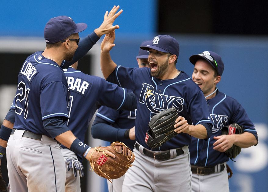 Tampa Bay Rays James Loney, left, Matt Joyce, center, and Sam Fuld, right, celebrate after the Rays defeated the Toronto Blue Jays 7-6 in a baseball game in Toronto on Sunday, Sept. 29, 2013. (AP Photo/The Canadian Press, Frank Gunn)