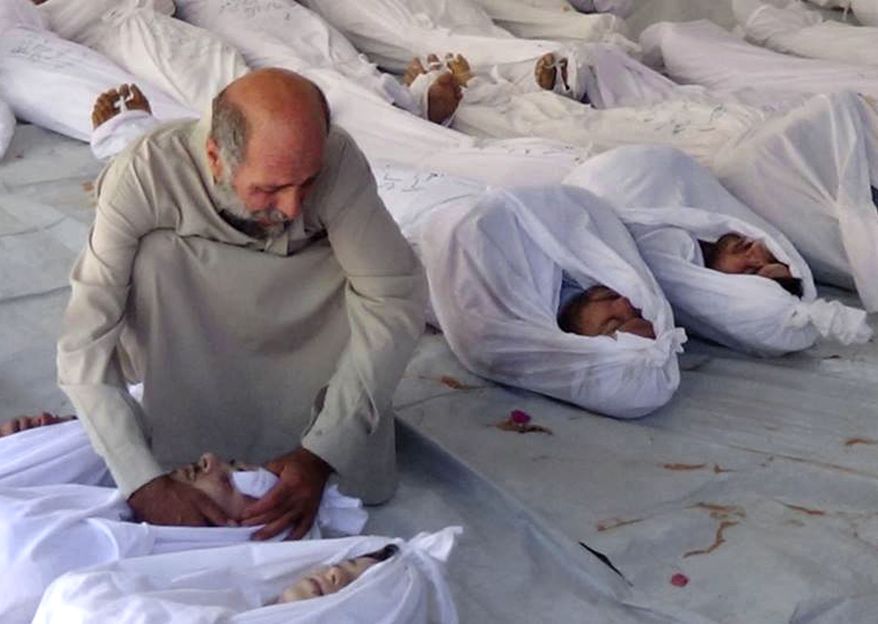 ** FILE ** A Syrian man mourns over a dead body after an alleged poisonous gas attack fired by regime forces, according to activists, in Douma town, near Damascus, Syria, on Wednesday, Aug. 21, 2013. (AP Photo/Media Office of Douma City)
