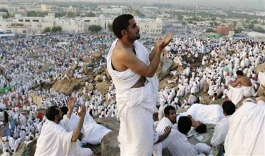 ** FILE ** Muslim pilgrims pray on a rocky hill called the Mountain of Mercy on the Plain of Arafat near the holy city of Mecca, Saudi Arabia, Oct. 25, 2012. (AP Photo/Hassan Ammar)