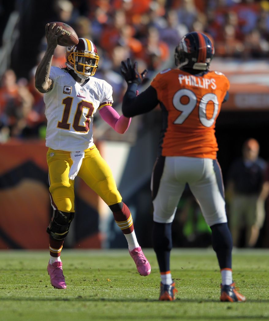 Washington Redskins quarterback Robert Griffin III (10) fakes a pass against Denver Broncos defensive end Shaun Phillips (90) in the second quarter of an NFL football game, Sunday, Oct. 27, 2013, in Denver. (AP Photo/Jack Dempsey)