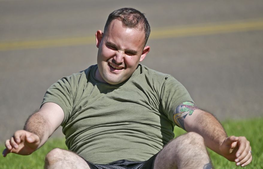 In a Wednesday, Oct. 16, 2013 photo, overweight service member who failed the so-called "tape test" struggles doing sit ups during a workout where he hopes to improve his conditioning and avoid being dismissed from the military, at the Marine Corps Recruit Depot in San Diego. Doctors say a number of military personnel are turning to liposuction to remove excess fat from around the waist so they can pass the Pentagon's body fat test. Some service members say they have no other choice because the Defense Department's method of estimating body fat is weeding out not just flabby physiques but bulkier, muscular builds. A number of fitness experts and doctors agree, and they're calling for the military's fitness standards to be revamped. (AP Photo/Lenny Ignelzi)