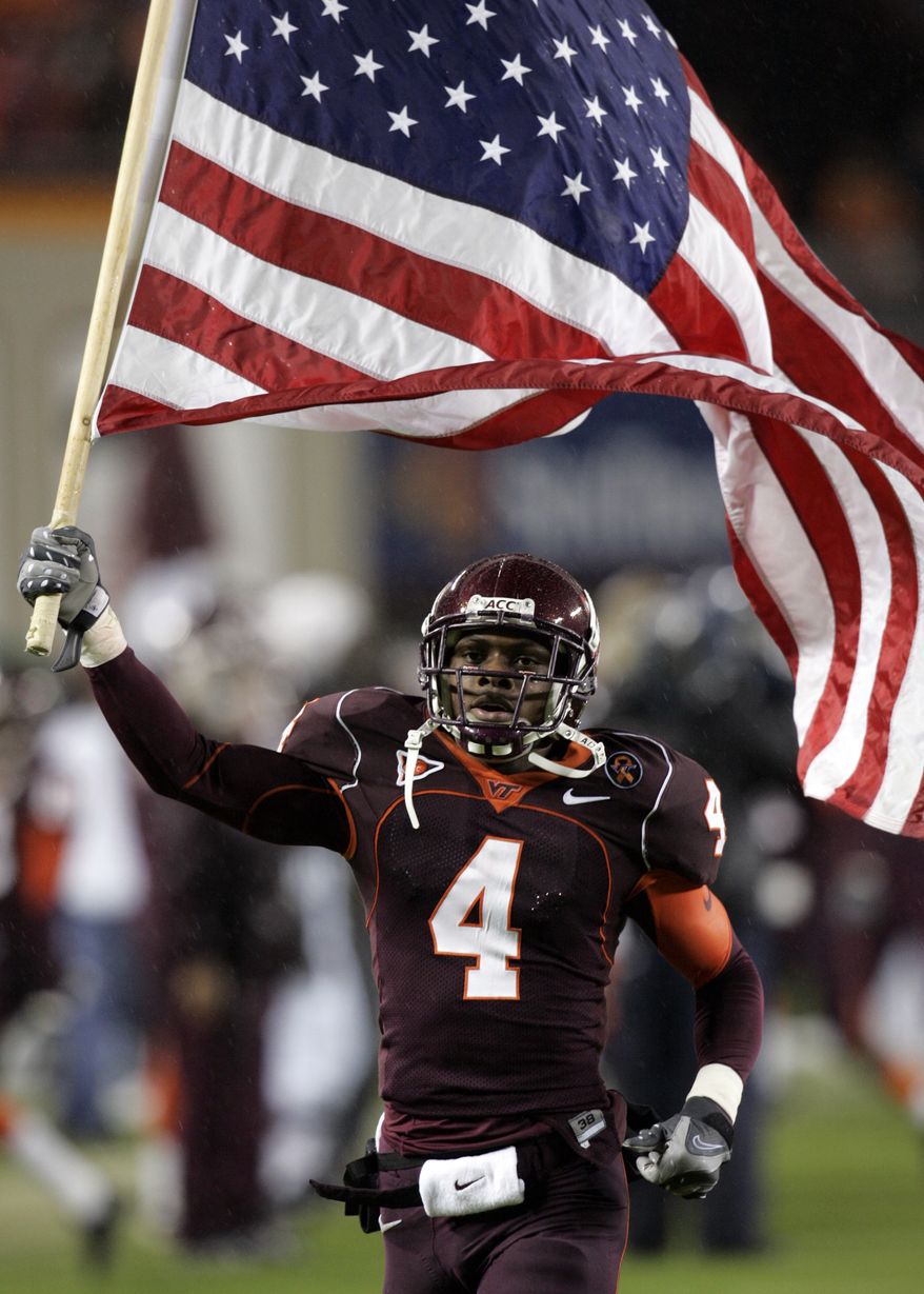 Virginia Tech flanker Eddie Royal (4) carries the US flag into the stadium prior to the Boston College-Virginia Tech college football game at Lane Stadium in Blacksburg, Va., Thursday, Oct. 25, 2007. BC won the game 14-10. (AP Photo/Steve Helber)