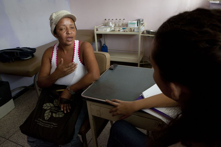 Evelina Gonzalez speaks with a psychologist at the Central Hospital in Maracay, Venezuela, on Oct. 28, 2013. She was supposed to have surgery in July following chemotherapy but was forced to shuttle from hospital to hospital in search of an available operating table, her tumor in the meanwhile more than doubling in size. The hospital's physicians sent some 300 patients in need of cancer operations home last month. Supply shortages, unsanitary conditions and equipment failures have forced them to scratch all but emergency surgeries. (AP Photo/Ariana Cubillos)