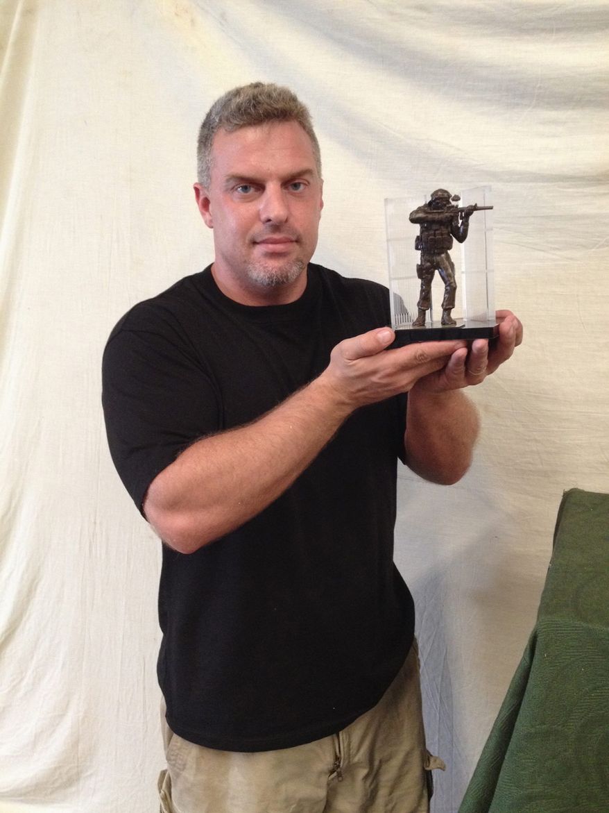 Gregory Marra shows a desktop version of a statue honoring SEAL Team 6's Operation Neptune Spear.