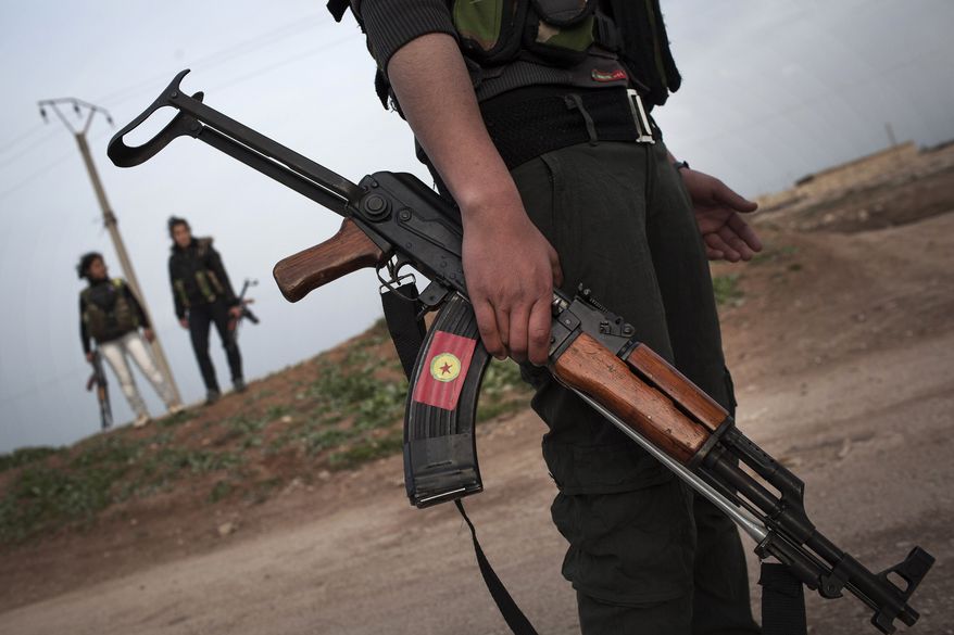 ** FILE ** In this Sunday, March. 3, 201,3 file photo, Kurdish female members, foreground and background, of the Popular Protection Units stand guard at a check point near the northeastern city of Qamishli, Syria. (AP Photo/Manu Brabo, File)