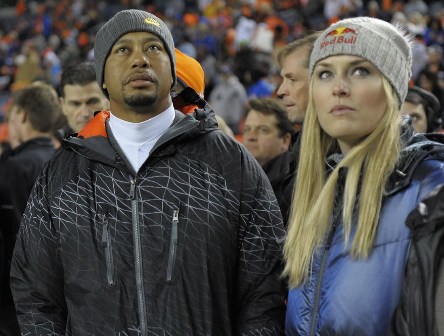 Tiger Woods, left, and Lindsey Vonn watch from the sidelines as the Denver Broncos and the Kansas City Chiefs warm up before an NFL football game, Sunday, Nov. 17, 2013, in Denver. (AP Photo/Jack Dempsey)
