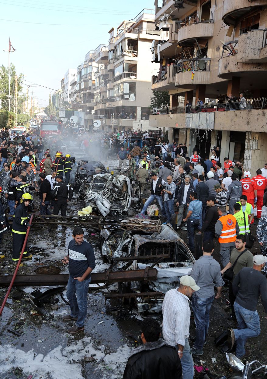 Lebanese people gather at the scene where two explosions have struck near the Iranian Embassy killing many, in Beirut, Lebanon, Tuesday, Nov. 19, 2013. The blasts in south Beirut's neighborhood of Janah also caused extensive damage on the nearby buildings and the Iranian mission. The area is a stronghold of the militant Hezbollah group, which is a main ally of Syrian President Bashar Assad in the civil war next door. It's not clear if the blasts are related to Syria's civil war. (AP Photo/Bilal Hussein)