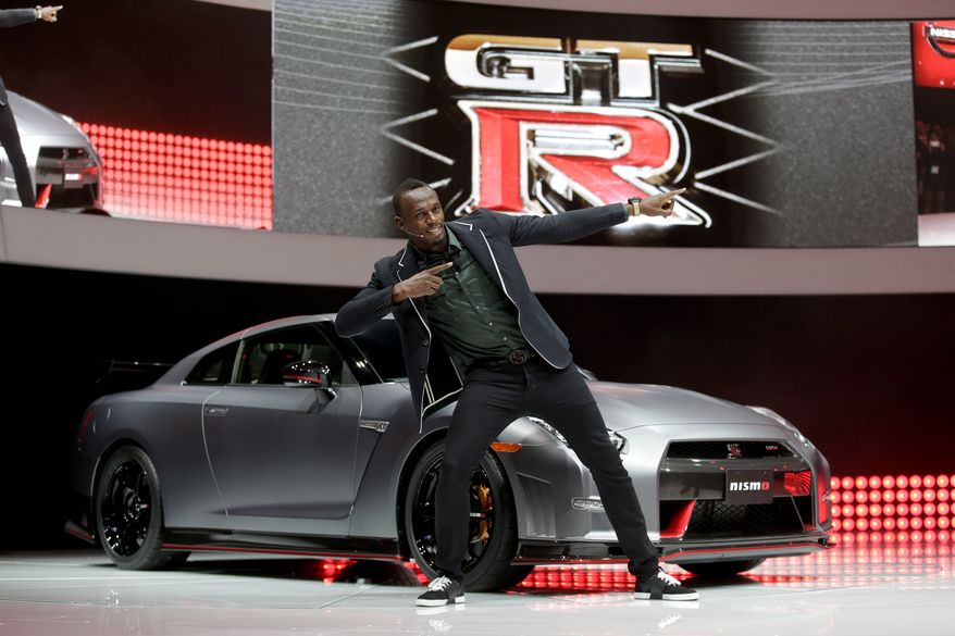 Olympic gold medalist, Usain Bolt poses in front of the the 2015 Nissan GT-R is debuted at the Los Angeles Auto Show in Los Angeles, Wednesday, Nov. 20, 2013. (AP Photo/Chris Carlson)