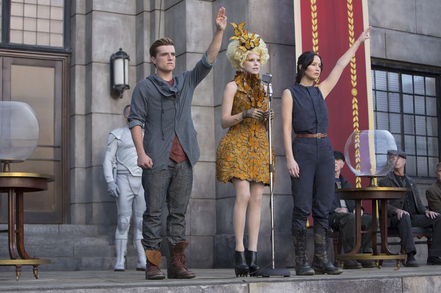 Josh Hutcherson, Elizabeth Banks (center) and Jennifer Lawrence are back for more "Hunger Games" in a fiery sequel cooked up for adolescent appetites. (Lionsgate via Associated Press)