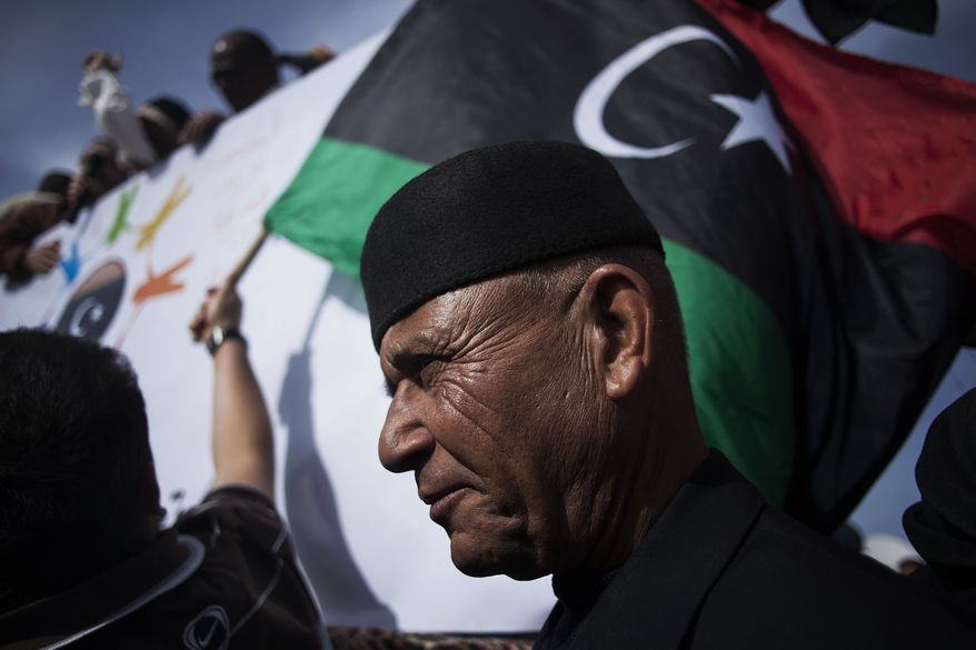 A Libyan man watches a protest against the Tripoli-based militias and supporting the new national army and the police corps in the Libyan capital Friday, Nov. 22, 2013. Thousands of protesters have gathered in Libya's capital to call on unlawful armed groups to leave the city, a week after militiamen killed more than 40 people. The head of Tripoli's local council, Al-Sadat al-Badri, told the crowd on Friday that the city will remain on strike until the capital and its surroundings are free of militias. (AP Photo/Manu Brabo)