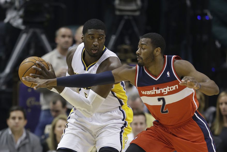 Indiana Pacers' Roy Hibbert, left, is defended by Washington Wizards' John Wall (2) during the first half of an NBA basketball game Friday, Nov. 29, 2013, in Indianapolis. (AP Photo/Darron Cummings)