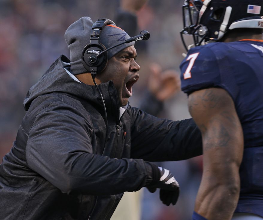 Virginia head coach Mike London reacts to a call during the first half of an NCAA college football game against Virginia Tech in Charlottesville, Va., Saturday, Nov. 30, 2013. (AP Photo/Steve Helber)