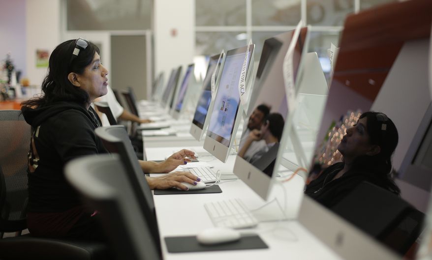 Rosemary Cabelo uses a computer at a public library to access the Affordable Health Care Act website, Wednesday, Dec. 11, 2013, in San Antonio. (AP Photo/Eric Gay)