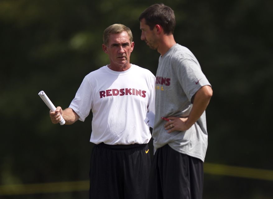 Washington Redskins head coach Mike Shanahan, left, talks with offensive coordinator Kyle Shanahan during the teams NFL football training camp practice on Tuesday, July 31, 2012 in Ashburn, Va. (AP Photo/Evan Vucci)