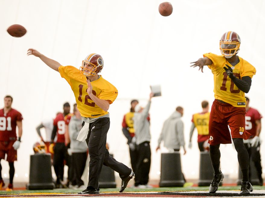 Washington Redskins quarterback Kirk Cousins (12) and Washington Redskins quarterback Robert Griffin III (10) throw at practice at Redskins Park, Ashburn, Va., Thursday, December 12, 2013. (Andrew Harnik/The Washington Times)