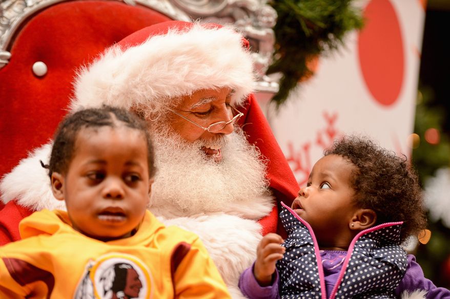 Christmas Color: Gyasi and Zara Cash of Temple Hills, Md., visit a popular black Santa Claus at the Mall at Prince George's in Hyattsville. (Andrew Harnik/The Washington Times)