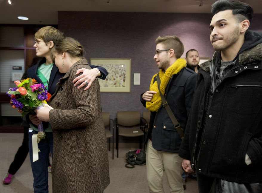 FILE - In this Dec. 20, 2013, file photo, same-sex couples Natalie Dicou, left, and Nichole Christensen, middle left, and James Goodman, middle right, and Jeffrey Gomez, right, wait in line to get a marriage license at the Salt Lake County Clerk's Office in Salt Lake City. Utah asked the U.S. Supreme Court on Tuesday, Dec. 31, 2013, for an emergency stay on more than 900 marriage licenses issued to gay couples since Dec. 20. (AP Photo/Kim Raff, File)