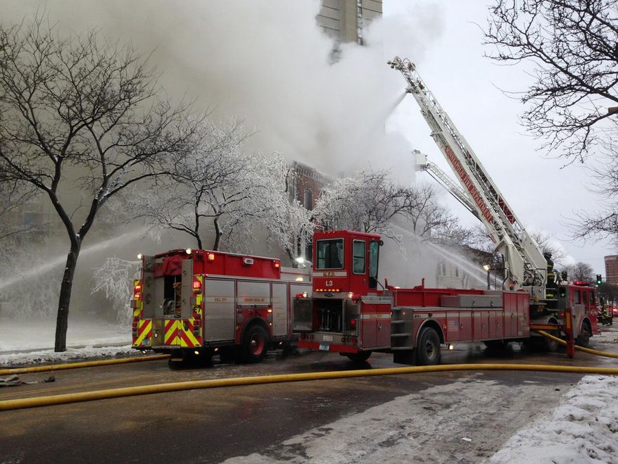 Firefighters work the scene where a fire engulfed several apartment units in the Cedar Riverside neighborhood in Minneapolis on Jan. 1, 2014. Authorities say at least 13 people have been hurt. (Associated Press/Star Tribune, McKenna Ewen)