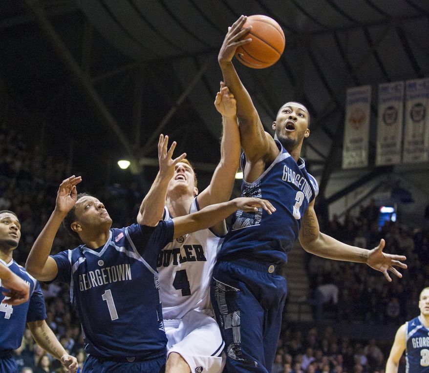 Butler's Erik Fromm (4) battles Georgetown's Mikael Hopkins (3) and Reggie Cameron (1) for a rebound in the first half of an NCAA college basketball game, Saturday, Jan. 11, 2014, in Indianapolis. (AP Photo/Doug McSchooler)