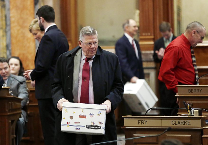 Rep. Dwayne Alons, R-Hull, carries a box to his desk during the opening day of the Iowa Legislature, Monday, Jan. 13, 2014, at the Statehouse in Des Moines, Iowa. (AP Photo/Charlie Neibergall)