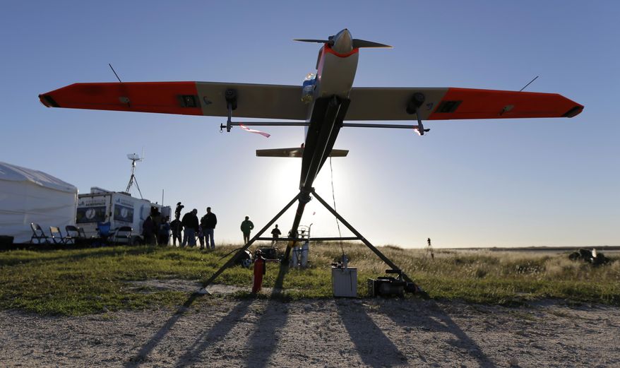 ** FILE ** Researchers prepare an unmanned aircraft system for testing at a ranch near Sarita, Texas, Jan. 15, 2014. The drone used by Texas A&M researchers weighs about 85 pounds and has a wing span of almost 13 feet. (AP Photo/Eric Gay)