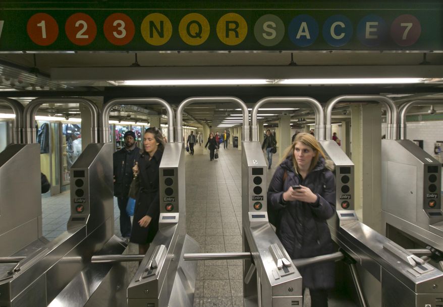 In this Dec. 4, 2013 photo, people move through the turnstiles in the subway in New York's Times Square station. Screeching subway trains emit considerable noise in a city with one of the nation's toughest noise codes. (AP Photo/Richard Drew)