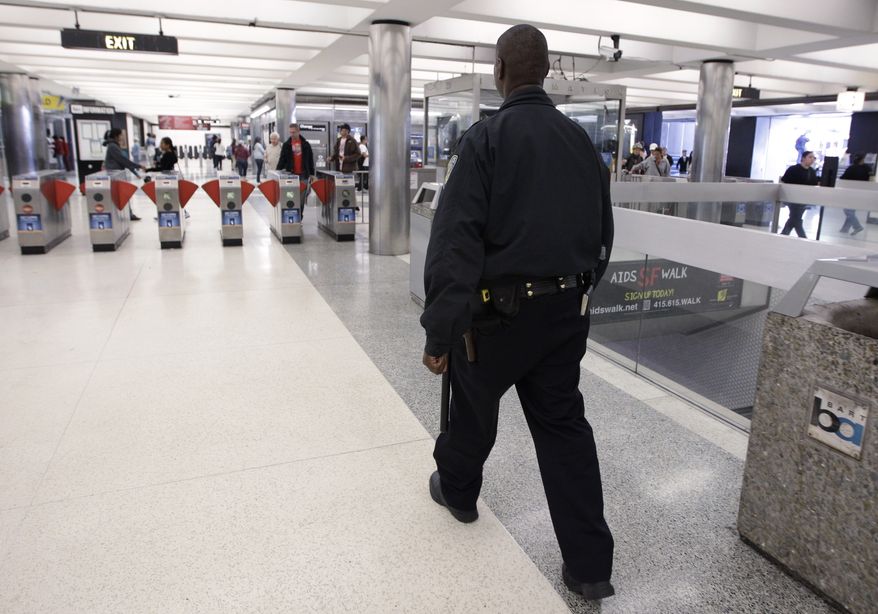 **FILE** In this Aug. 26, 2011 photo, a Bay Area Rapid Transit (BART) police officer walks around the Civic Center stop in San Francisco. (AP Photo/Paul Sakuma)