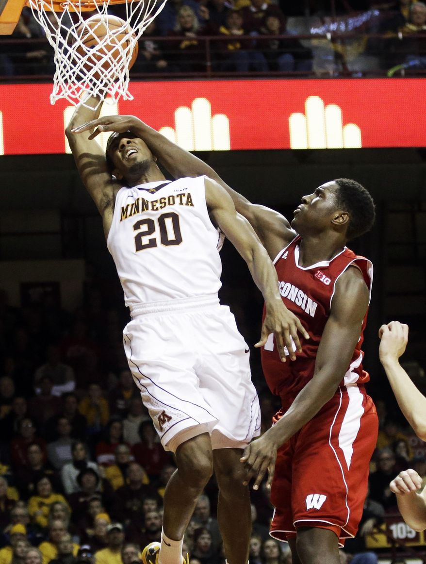 Minnesota's Austin Hollins, left, is fouled by Wisconsin's Nigel Hayes but manages to dunk the ball in the second half of an NCAA college basketball game, Wednesday, Jan. 22, 2014, in Minneapolis. Minnesota won 81-68. (AP Photo/Jim Mone)