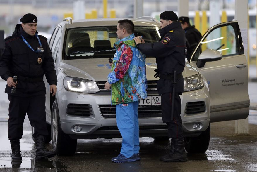 A Russian police officer searches a driver as his vehicle is also screened at an entrance to the Sochi 2014 Olympic Winter Games park, Thursday, Jan. 23, 2014, in Sochi, Russia. The Olympics begin on Feb. 7. (AP Photo/David J. Phillip)