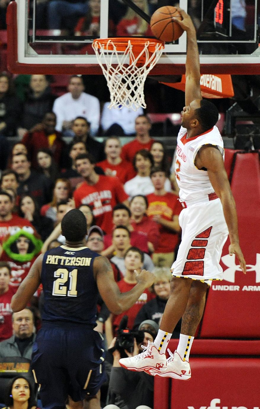 Maryland's Dez Wells, right, scores as Pittsburgh's Lamar Patterson stands near in the first half of an NCAA college basketball game Saturday, Jan. 25, 2014, in College Park, Md. (AP Photo/Gail Burton)