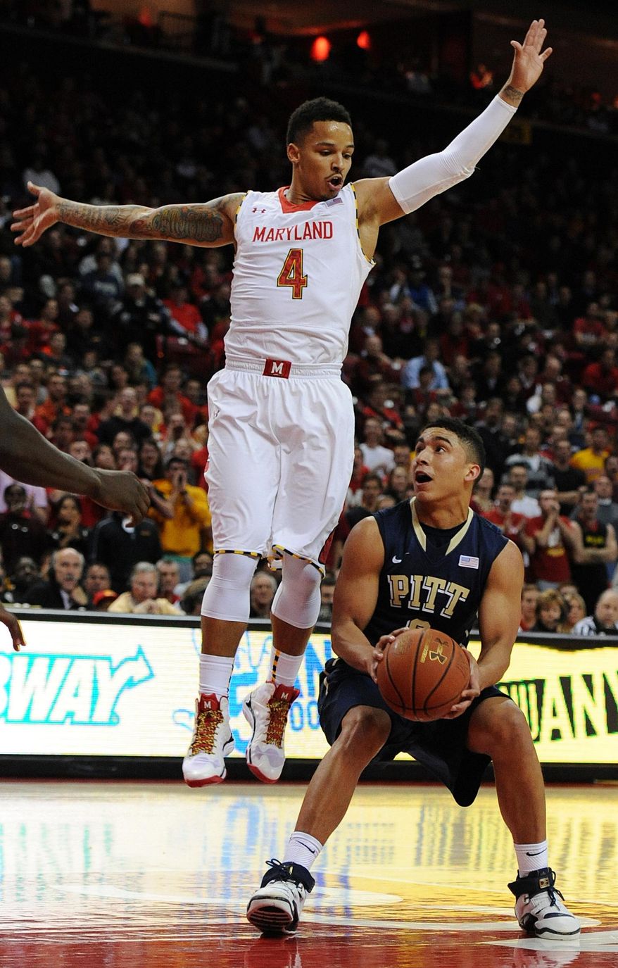 Maryland's Seth Allen, left, jumps to block as Pittsburgh's James Robinson looks to shoot in the first half of an NCAA college basketball game Saturday, Jan. 25, 2014, in College Park, Md. (AP Photo/Gail Burton)