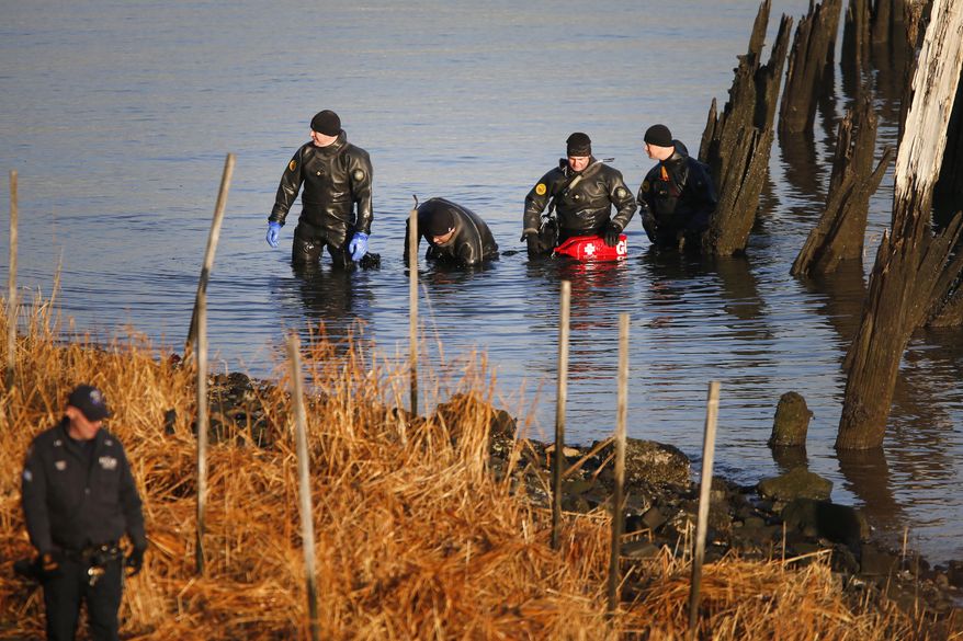 FILE - In this Friday, Jan. 17, 2014, file photo, after an arm, torso and legs were discovered a day earlier, a New York Police Department dive unit continues the search for human remains along a rocky shoreline in the Queens borough of New York. The remains were those of missing autistic teenager Avonte Oquendo. The U.S. Department of Justice said Wednesday, Jan. 29, 2014, it will fund voluntary tracking devices for children with autism or other conditions that put them at risk for fleeing their caregivers. (AP Photo/Jason DeCrow, File)