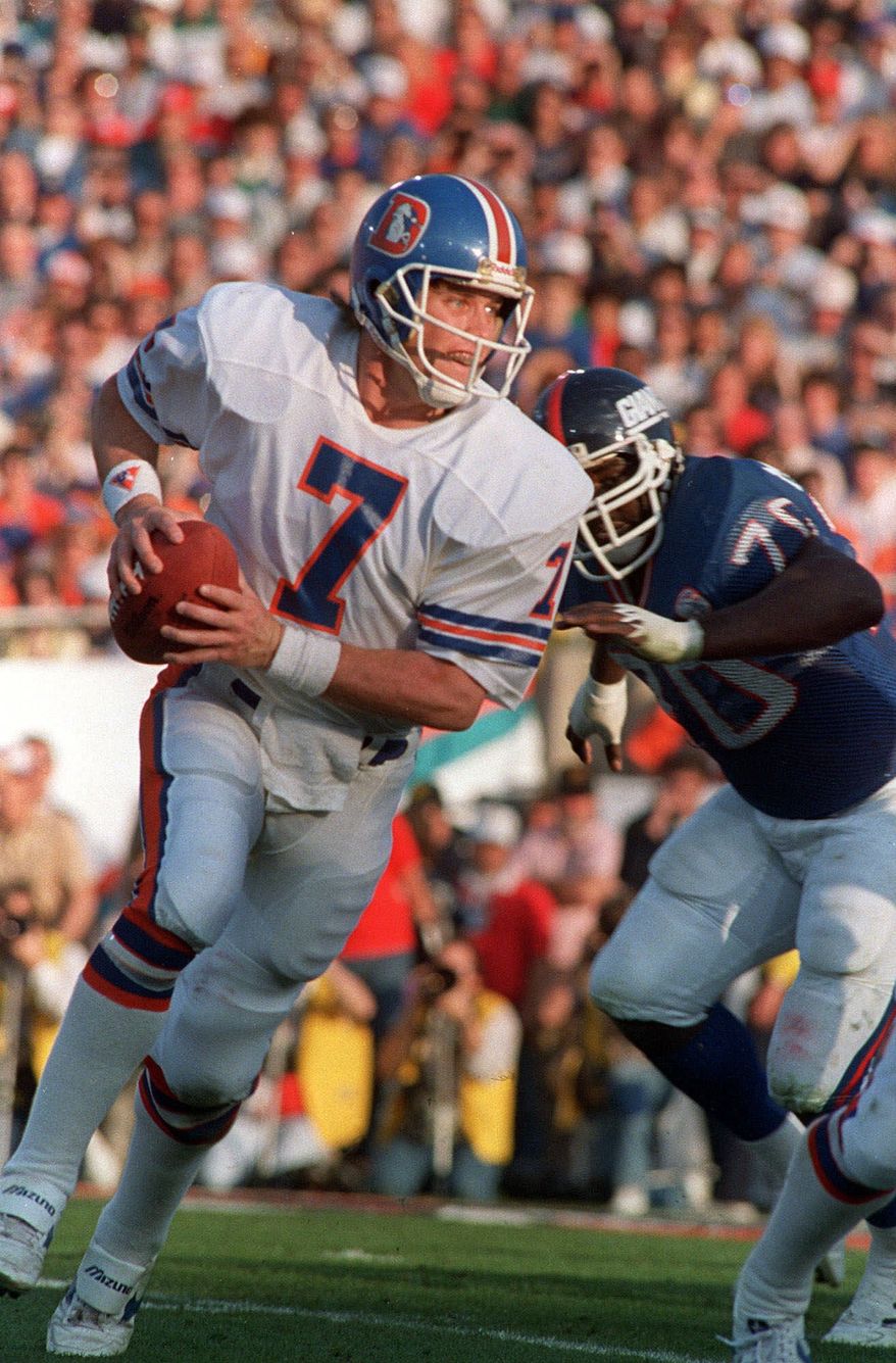 Denver Broncos John Elway is chased by New York Giants Leonard Marshall in Super Bowl XXI in Pasadena, Calif. Jan. 25, 1987. ( AP Photo/Amy Sancetta)
