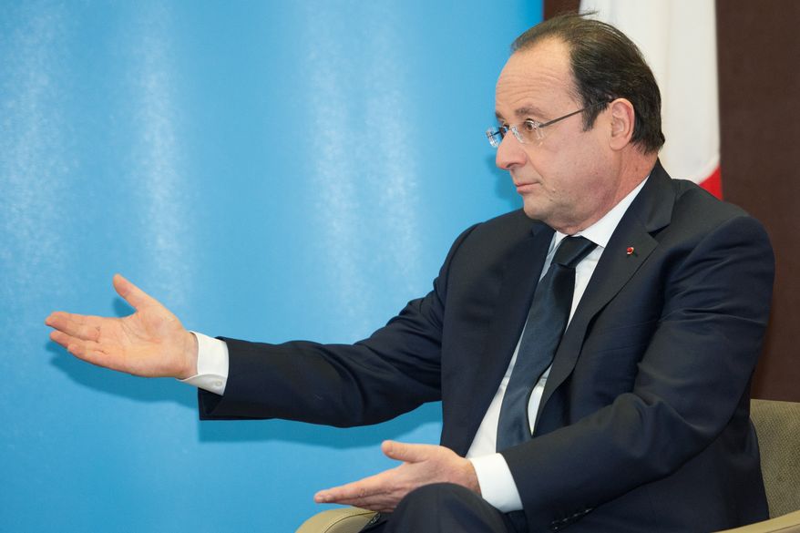 French President Francois Hollande raises his arms as he speaks during a meeting with British Prime Minister David Cameron during a one day summit at RAF Brize Norton, Brize Norton, England on Friday, Jan. 31, 2014. The one-day summit is expected to cover military cooperation, including talks over armed drones, anti-ship missiles, and underwater mine detectors, as well as a joint Franco-British force of 10,000 soldiers due to be formed in the next few years. (AP Photo/Leon Neal, Pool).