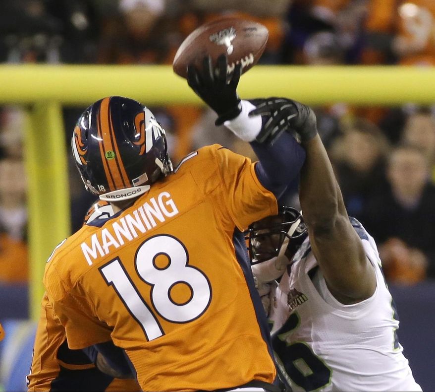 Denver Broncos' Peyton Manning is hit by Seattle Seahawks' Cliff Avril as he throws an interception during the first half of the NFL Super Bowl XLVIII football game Sunday, Feb. 2, 2014, in East Rutherford, N.J. (AP Photo/Mark Humphrey)