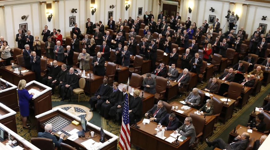 Members of the Oklahoma Legislature applaud as Oklahoma Governor Mary Fallin, left, gives her State of the State address in Oklahoma City, Monday, Feb. 3, 2014. (AP Photo/Sue Ogrocki)