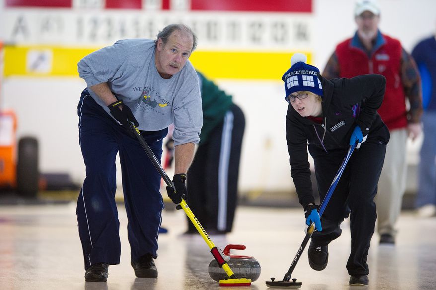 George Shirk of the Potomac Curling Club and Leticia Young of the Plainfield Curling Club compete in the games held in Laurel, Md. (Preston Keres/Special to The Washington Times)