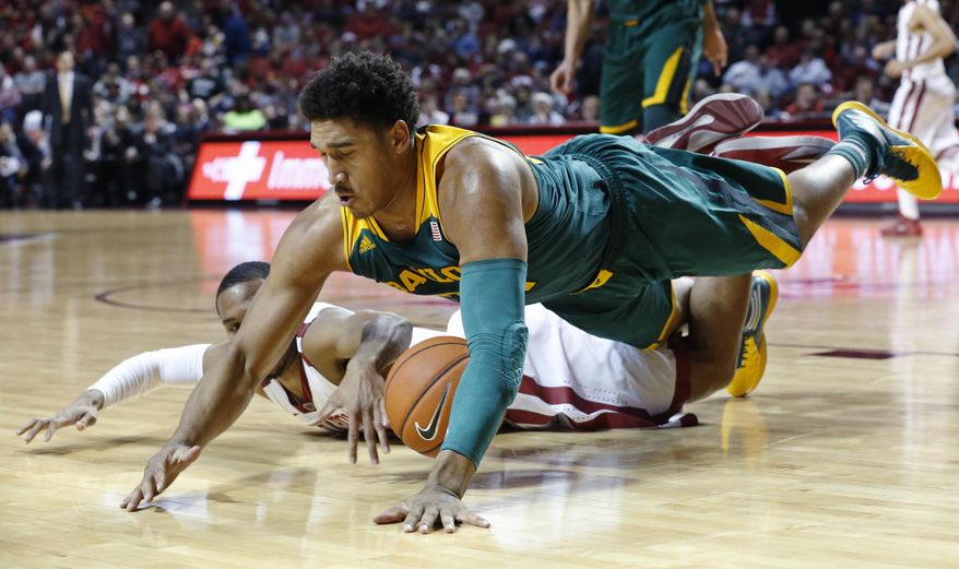 Baylor guard Ish Wainright, top, dives over Oklahoma guard Jordan Woodard for a loose ball in the first half of an NCAA college basketball game in Norman, Okla., Saturday, Feb. 8, 2014. (AP Photo/Sue Ogrocki)