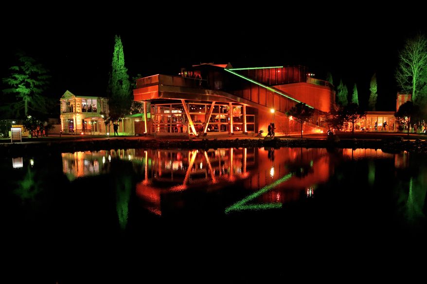 FILE - In this Feb. 8, 2014 file photo, the orange-lit Holland Heineken House is reflected in a pond following the appearance of gold medalist Sven Kramer of the Netherlands on stage in front of fans after he set a new Olympic record to win the 5,000-meter speedskating race at the 2014 Winter Olympics in Sochi, Russia. With Dutch speedskaters dominating the 2014 Winter Olympics like never before, the Holland House has become the house of champions. (AP Photo/Matt Dunham, File)